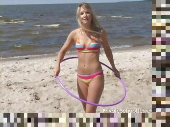 Bikini teen strips on the beach and hula hoops in the nude