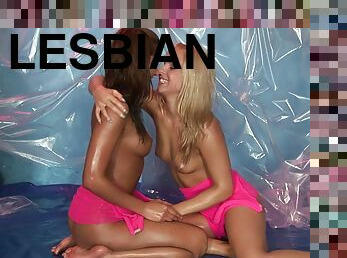 Lesbian coeds oil up a tarp and have fun toying each other