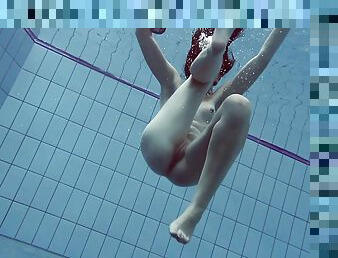 Slender raven-haired stunner undresses while diving in the pool