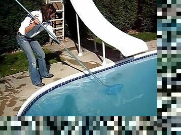 Cute black-haired babe rescuing a frog out of the pool