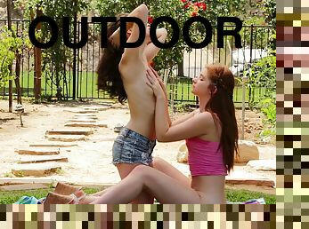 Two girls lay down a towel then get each other off outdoors