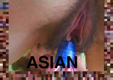 Alluring Asian solo model teases her hairy pussy with a toy close up
