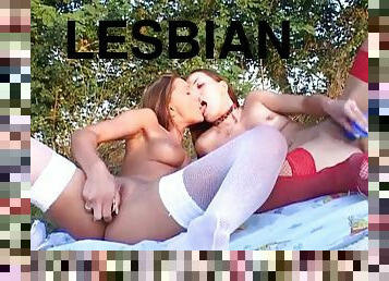 Ladies in their lingerie have lesbian sex on a blanket outdoors