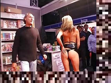 Captivating cougar in sexy thong drilling her shaved pussy with monster dildo in public