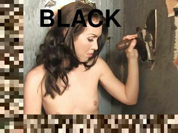 Maggie Matthews sucks on a monster black cock through a gloryhole