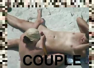 Horny couple stimulate each other's privates on a beach