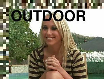 Blonde hottie Carla Cox gives an interview on the poolside