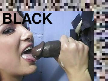 A white girl loves sucking black cock in a gloryhole