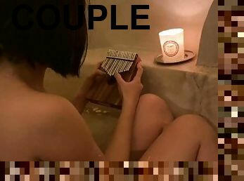 Girl playing instrument for boyfriend in bathtub