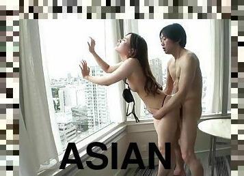 Slim Asian babe gets fucked in front of a window