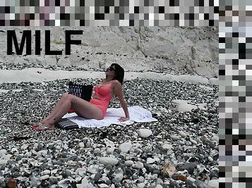 Sexy brunette undressed on nude beach