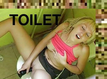 Cute lady playing with a dildo inside a toilet