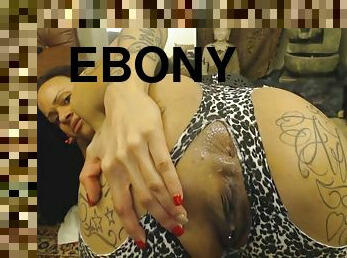 A dirty-talking, fowl mouth Ebony woman with tattoos performs a webcam show.