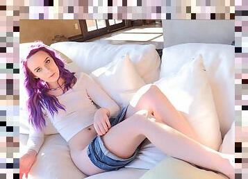 Purple-haired Jessica lying in bed stroking her quivering pussy