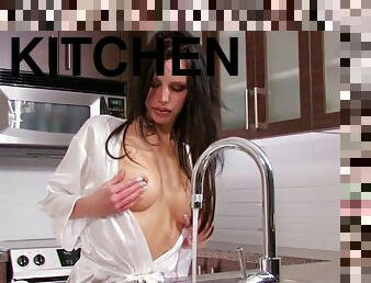 Horny sex bomb masturbates with water in a kitchen