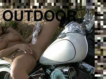Hot babe on a motorcycle fucks a toy erotically