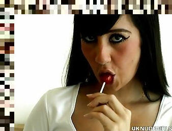 Hottie sucks on a red lollipop and fucks a dildo