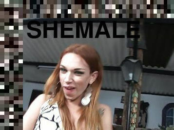 A redheaded shemale pumps her thick cock until she cums