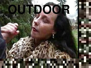 Chick in fur coat giving handjob outdoors