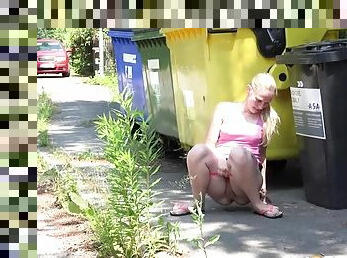 Girl on a public street squats to piss