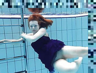 Russian redhead babe displaying her shaved pussy when swimming