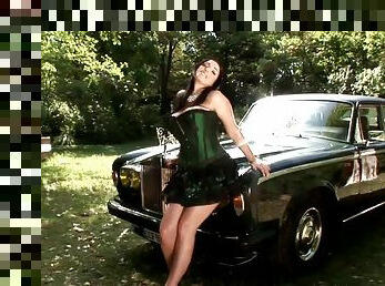 Busty Brunette Poses on Classic Car Wearing a Sexy Outfit