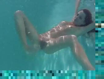 Slim redhead in bikini gets naked underwater