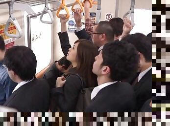 A very daring Japanese babe sucks a guy's cock on a crowded subway