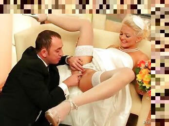 Pretty blonde bride giving her husband a blowjob