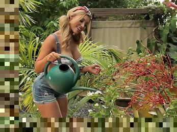 Smoking hot blonde parades her big fake tits at her flower garden outdoors