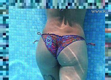 Curvy bikini girl shows off her tattooed body in the pool