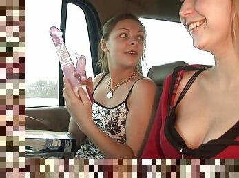 Two lesbian friends having fun with sex toys under the blue sky