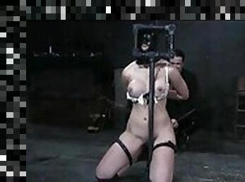 Girl in a wild bondage device caned