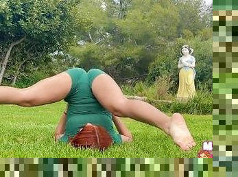Pelirroja hace estiramientos sensuales de Yoga en el parque para que la observen