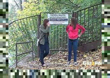 Two cute girls pee in the leaves outdoors